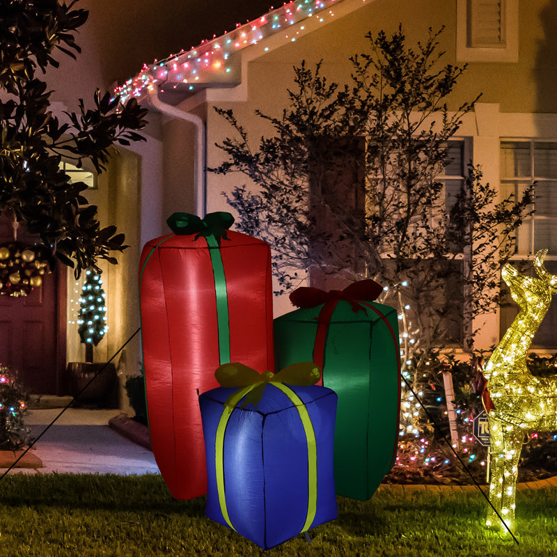 Inflatable present trio outside at night.