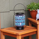 Blue mosaic lantern sitting on a wooden table.