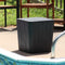 Black faux wood 2-in-1 storage box sitting next a pool on a sunny day.