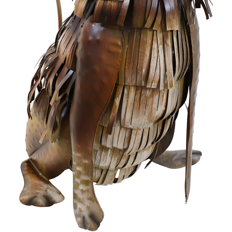 Back view of metal rustic dog with fringe-like hair and floppy ears.