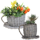 Two wicker teacup planters with flowers