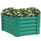 Green, hexagon raised garden bed with white flowers.