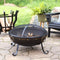 Black, metal, Victorian style fire pit burns on a stone patio while the spark screen protects stray embers from flying.