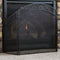 Decorative metal fireplace screen in front of an indoor fireplace to protect rogue sparks and ash.
