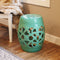 Jade green knotted quatrefoil ceramic garden stool sitting on hardwood floor  