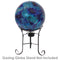 Deep ocean blue gazing globe with mosaic crackled glass pattern sitting in a black metal gazing globe stand.