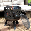 A retro-inspired fire pit sits on a patio in front of a gray sofa with it's spark screen off and resting on the side. 