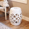 White knotted quatrefoil ceramic garden stool sitting on hardwood floor  