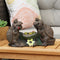 Tic Tac Toe Turtle statue is sitting on a light brown wooden patio table; behind them rests a mandalas-inspired pillow.