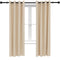 Two beige indoor/outdoor curtains on a black curtain rod in front of a white window.